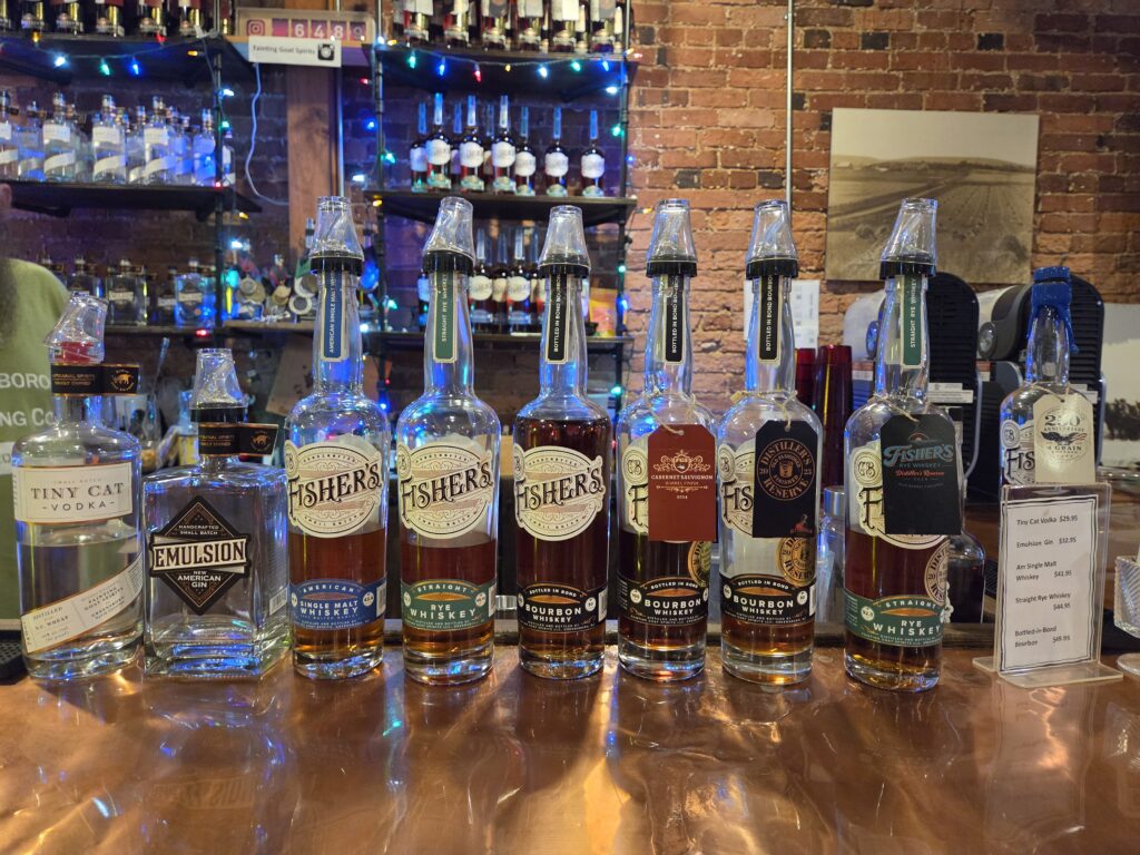Greensboro: Big, Unexpected Adventures From 1781 Battlefield to Jeansboro 47 A lineup of Fisher's bottles showing the array of distilled spirits at the Fainting Goat.