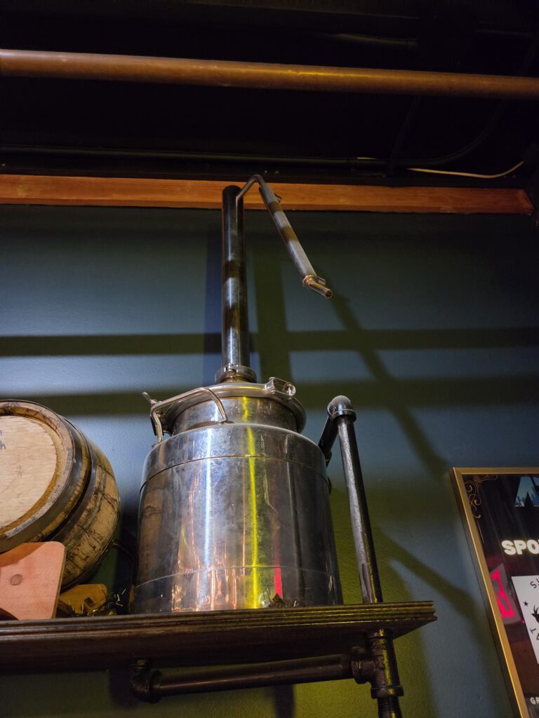 Greensboro: Big, Unexpected Adventures From 1781 Battlefield to Jeansboro 46 A small stainless steel still on a shelf.