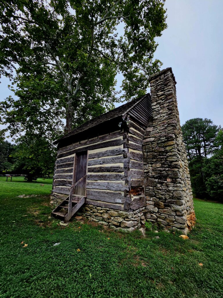 Greensboro: Big, Unexpected Adventures From 1781 Battlefield to Jeansboro 16 Closeup of log house with rock chimney and foundation.