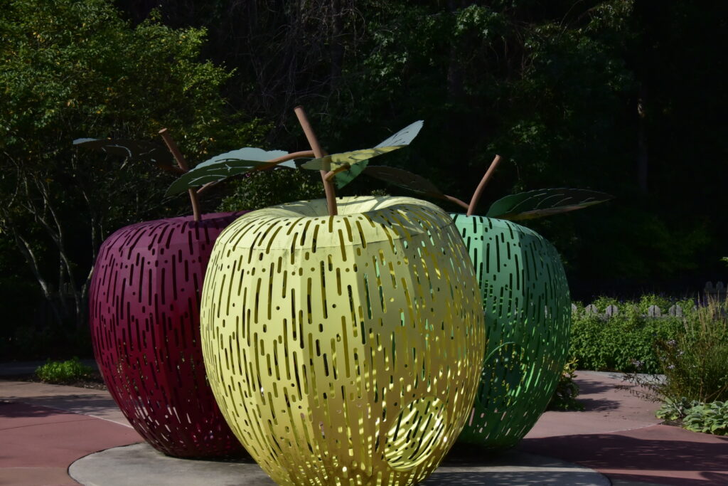 Greensboro: Big, Unexpected Adventures From 1781 Battlefield to Jeansboro 3 Large metal sculptures of apples, red, green & yellow - one of each in the children's garden.