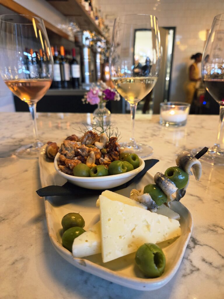 Greensboro: Big, Unexpected Adventures From 1781 Battlefield to Jeansboro 42 A triangular plate filled with olives, cheeses, and stuffed dates (in a small bowl).